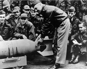 Photograph of James Doolittle affixing Japanese medal to a
        bomb