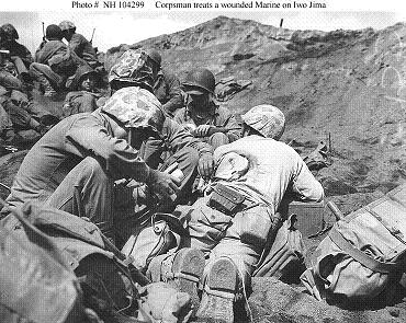 Photograph of corpsman treating a back wound